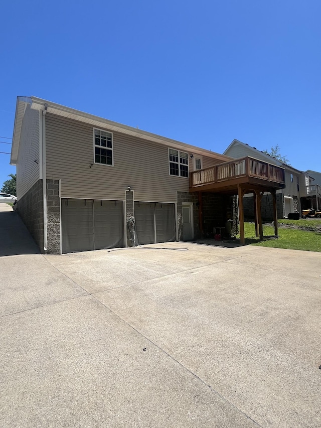 924 Granny White Rd, Clarksville, TN 37040 - rear view of house featuring an attached garage, concrete driveway, and a wooden deck