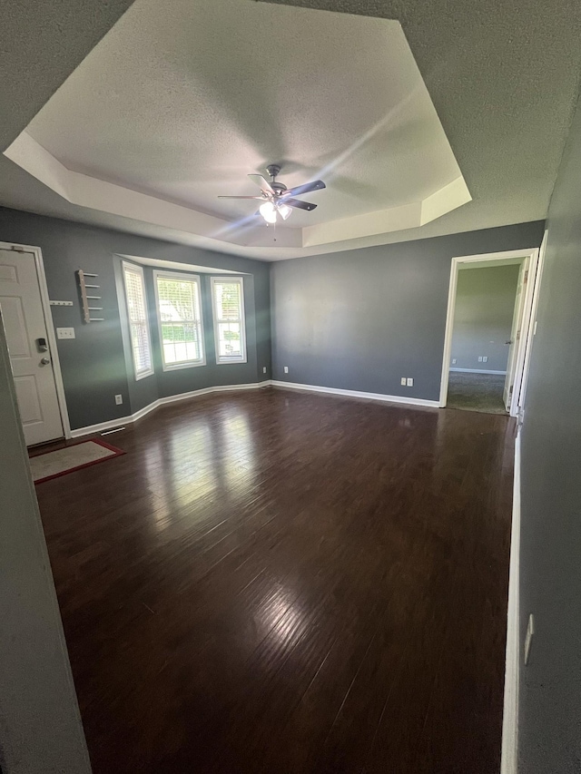 924 Granny White Rd, Clarksville, TN 37040 - empty room with a tray ceiling, baseboards, a ceiling fan, a textured ceiling, and wood finished floors
