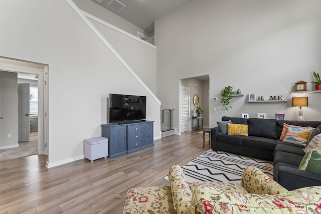360 Gulfstream Dr, Gallatin, TN 37066 - living room featuring a towering ceiling, light wood-type flooring, baseboards, and stairs
