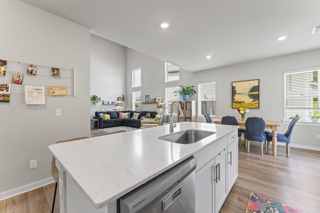 360 Gulfstream Dr, Gallatin, TN 37066 - kitchen with stainless steel dishwasher, a sink, baseboards, white cabinets, and light stone countertops