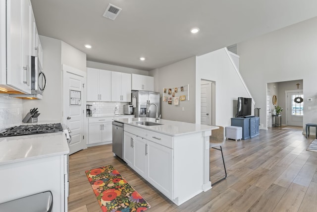 360 Gulfstream Dr, Gallatin, TN 37066 - kitchen featuring a sink, appliances with stainless steel finishes, backsplash, a breakfast bar, and white cabinetry
