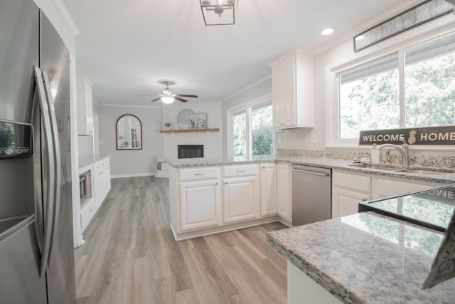 204 Tyne Blvd, Old Hickory, TN 37138 - kitchen with appliances with stainless steel finishes, a brick fireplace, ornamental molding, a sink, and a peninsula