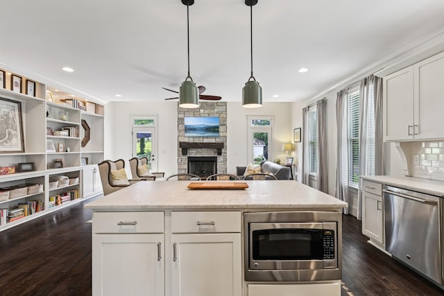 2809 Vaulx Ln, Nashville, TN 37204 - kitchen featuring appliances with stainless steel finishes, dark wood finished floors, a fireplace, a ceiling fan, and recessed lighting