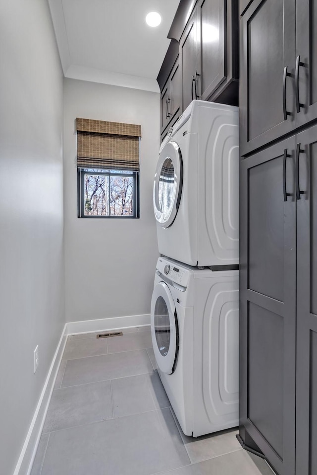 337 Lake Court Dr, Lynchburg, TN 37352 - washroom featuring cabinet space, stacked washing machine and dryer, baseboards, light tile patterned floors, and crown molding
