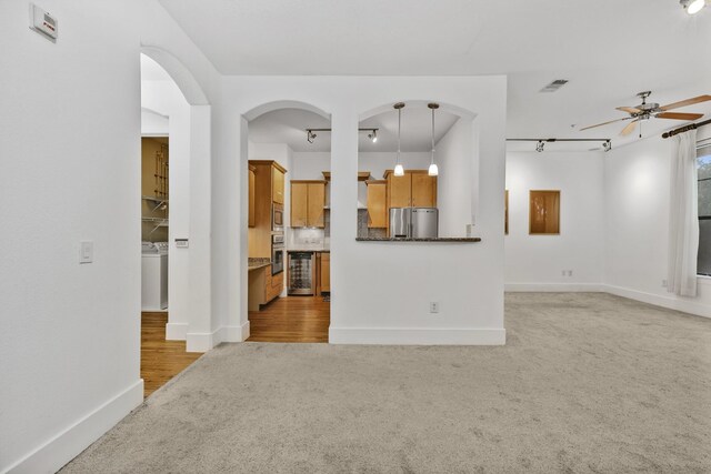 2600 Hillsboro Pike # 233, Nashville, TN 37212 - unfurnished living room featuring rail lighting, a ceiling fan, baseboards, light carpet, and arched walkways
