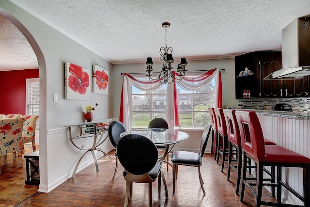 1611 Saltlick Pl, Murfreesboro, TN 37129 - dining area with arched walkways, wood finished floors, a textured ceiling, a chandelier, and wainscoting