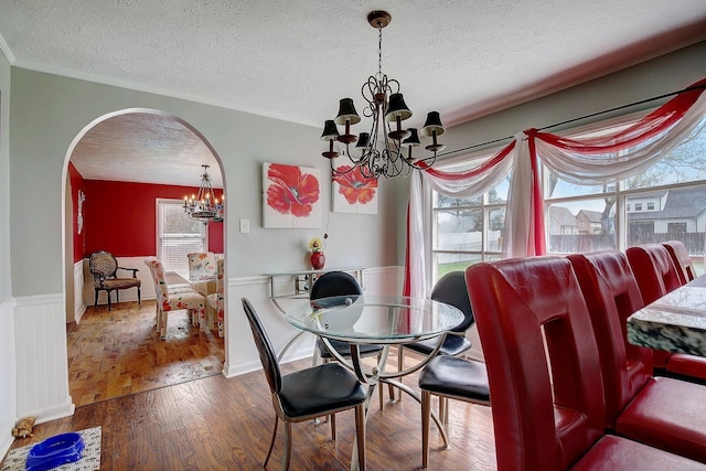 1611 Saltlick Pl, Murfreesboro, TN 37129 - dining area with a chandelier, a textured ceiling, arched walkways, wood finished floors, and a wainscoted wall
