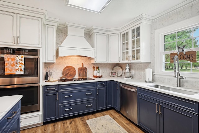 3411 Murphy Ln, Columbia, TN 38401 - kitchen with appliances with stainless steel finishes, blue cabinets, premium range hood, a sink, and white cabinetry
