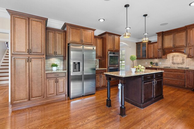 1005 Brittain Downs Dr, Nolensville, TN 37135 - kitchen with stainless steel appliances, arched walkways, dark wood-style flooring, tasteful backsplash, and a center island