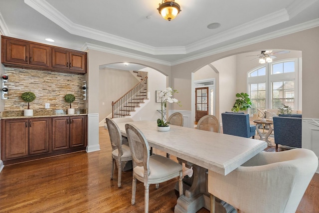 1005 Brittain Downs Dr, Nolensville, TN 37135 - dining room featuring arched walkways, a tray ceiling, stairway, dark wood-style floors, and crown molding