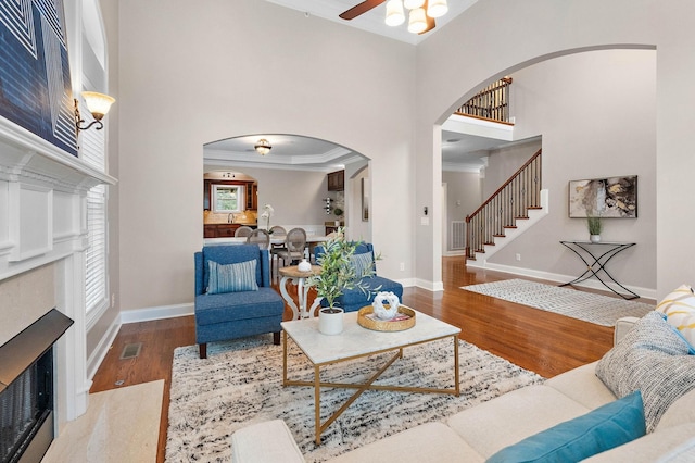 1005 Brittain Downs Dr, Nolensville, TN 37135 - living area with arched walkways, ceiling fan, a fireplace with flush hearth, wood finished floors, and a high ceiling