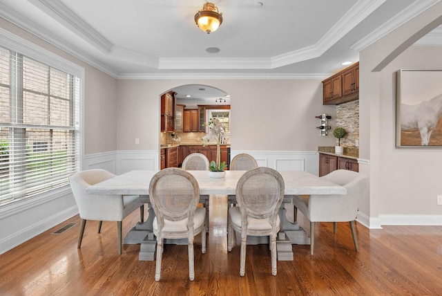 1005 Brittain Downs Dr, Nolensville, TN 37135 - dining area featuring a raised ceiling, arched walkways, wood finished floors, wainscoting, and ornamental molding