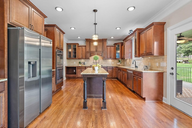 1005 Brittain Downs Dr, Nolensville, TN 37135 - kitchen with appliances with stainless steel finishes, brown cabinetry, crown molding, light wood-style flooring, and recessed lighting
