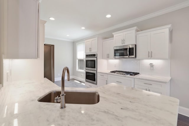 212 Lotus Ct, Hendersonville, TN 37075 - kitchen with stainless steel appliances, baseboards, a sink, ornamental molding, and light stone countertops