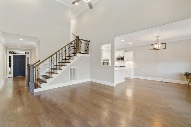 212 Lotus Ct, Hendersonville, TN 37075 - unfurnished living room with ornamental molding, stairway, a chandelier, wood finished floors, and a ceiling fan