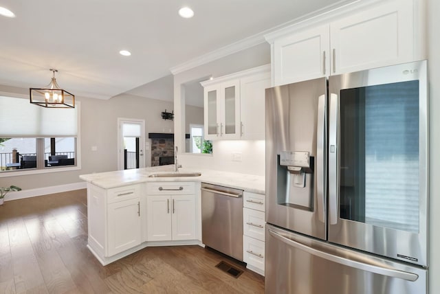 212 Lotus Ct, Hendersonville, TN 37075 - kitchen with appliances with stainless steel finishes, a sink, a peninsula, white cabinetry, and glass insert cabinets