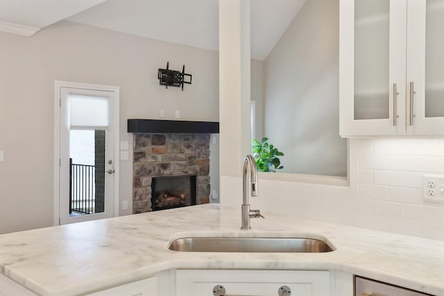 212 Lotus Ct, Hendersonville, TN 37075 - kitchen with a sink, backsplash, white cabinetry, light stone counters, and lofted ceiling