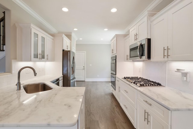 212 Lotus Ct, Hendersonville, TN 37075 - kitchen featuring appliances with stainless steel finishes, a sink, white cabinets, crown molding, and light stone counters