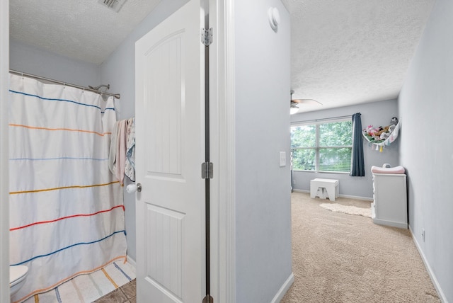 4115 Giacomo Dr, Murfreesboro, TN 37128 - bathroom featuring a textured ceiling, baseboards, curtained shower, toilet, and a ceiling fan