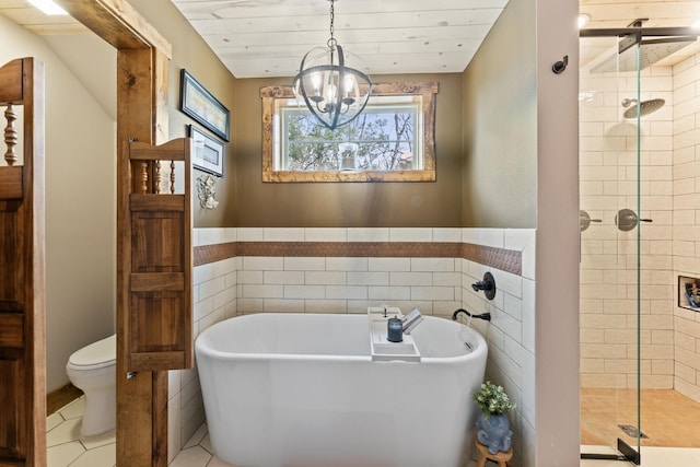 860 Old Woodbury Pike, Readyville, TN 37149 - bathroom featuring a shower stall, tile walls, toilet, a freestanding tub, and a chandelier