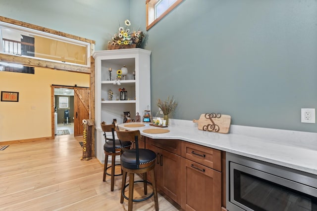860 Old Woodbury Pike, Readyville, TN 37149 - bar area featuring stainless steel microwave, a barn door, light wood finished floors, and plenty of natural light