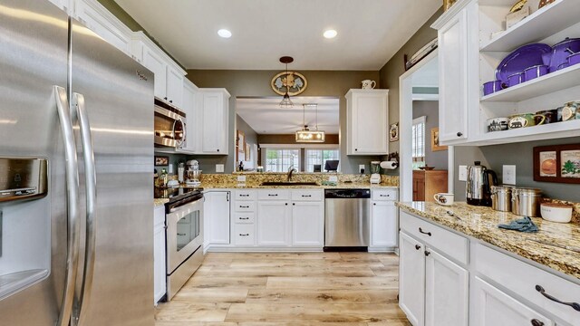 402 Cottonwood Dr, Mount Juliet, TN 37122 - kitchen featuring appliances with stainless steel finishes, a sink, light wood-type flooring, white cabinets, and decorative light fixtures