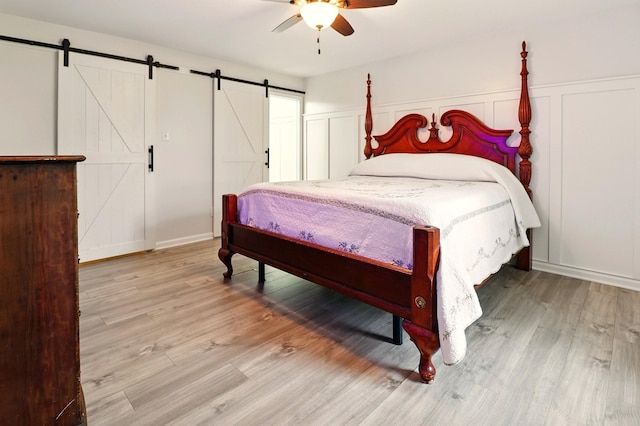 1864 Sawgrass Ln, Chapel Hill, TN 37034 - bedroom featuring a barn door, wood finished floors, a decorative wall, and ceiling fan