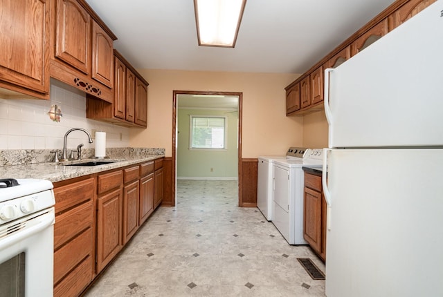 942 Youngs Ln, Nashville, TN 37207 - kitchen with white appliances, a sink, washing machine and dryer, light flooring, and brown cabinets