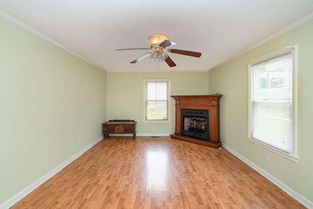 942 Youngs Ln, Nashville, TN 37207 - unfurnished living room featuring light wood-style flooring, crown molding, a fireplace with raised hearth, ceiling fan, and baseboards