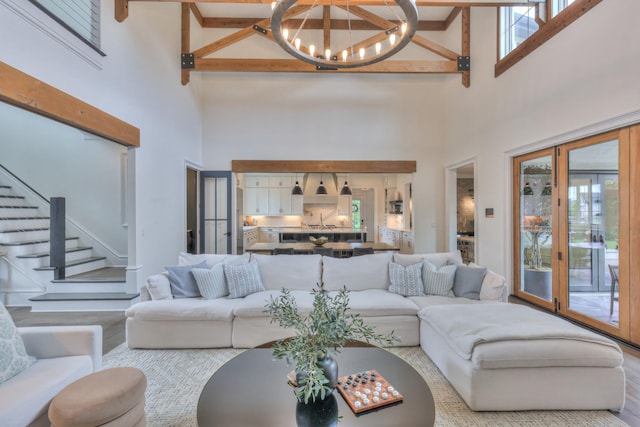 1021 Julian Way, Murfreesboro, TN 37128 - living room featuring a high ceiling, plenty of natural light, a chandelier, stairs, and wood finished floors