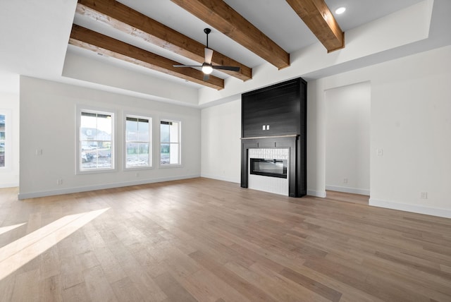 24 Fawn Mdws, Clarksville, TN 37043 - unfurnished living room with ceiling fan, beam ceiling, light wood-type flooring, baseboards, and a large fireplace