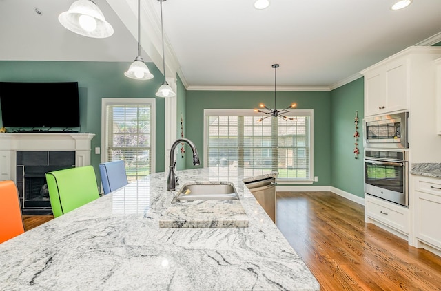 4423 Garcia Blvd, Murfreesboro, TN 37128 - kitchen featuring stainless steel appliances, a sink, a chandelier, crown molding, and light stone counters
