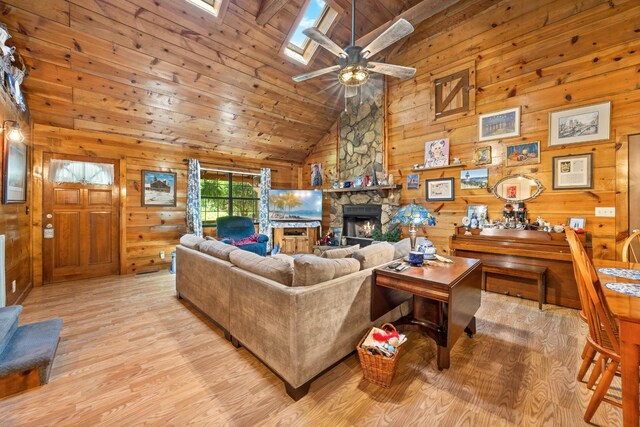 123 Hidden Trl, Dover, TN 37058 - living room featuring high vaulted ceiling, wood walls, light wood-style floors, a ceiling fan, and a fireplace