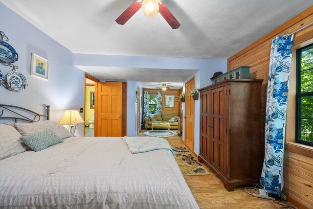 123 Hidden Trl, Dover, TN 37058 - bedroom with wooden walls, light wood-type flooring, and a ceiling fan