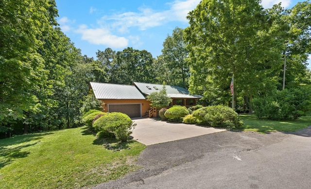 123 Hidden Trl, Dover, TN 37058 - view of front of house featuring a garage, a front yard, driveway, and metal roof