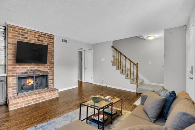 523 Williamsburg Dr, Nashville, TN 37214 - living area featuring wood finished floors, stairway, a brick fireplace, a textured ceiling, and baseboards