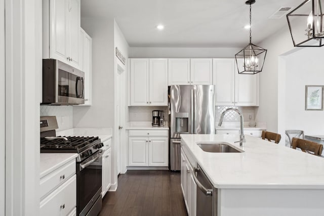 9420 Kaplan Ave, Brentwood, TN 37027 - kitchen with stainless steel appliances, a sink, dark wood finished floors, a chandelier, and backsplash