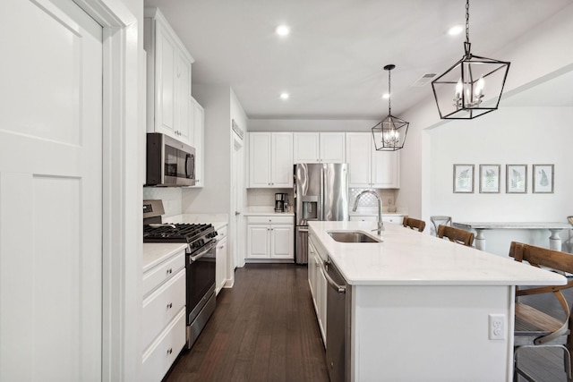 9420 Kaplan Ave, Brentwood, TN 37027 - kitchen featuring appliances with stainless steel finishes, a sink, a kitchen bar, a chandelier, and white cabinetry