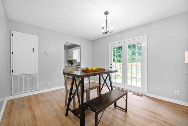 271 Golden Pond Ave, Oak Grove, KY 42262 - dining space with light wood finished floors, a chandelier, baseboards, and a textured ceiling