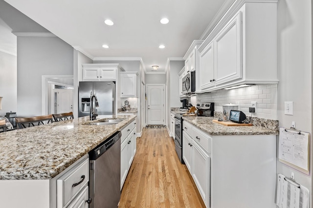 2520 Pebblecreek Ln, Murfreesboro, TN 37130 - kitchen with appliances with stainless steel finishes, ornamental molding, a sink, white cabinetry, and light wood-type flooring