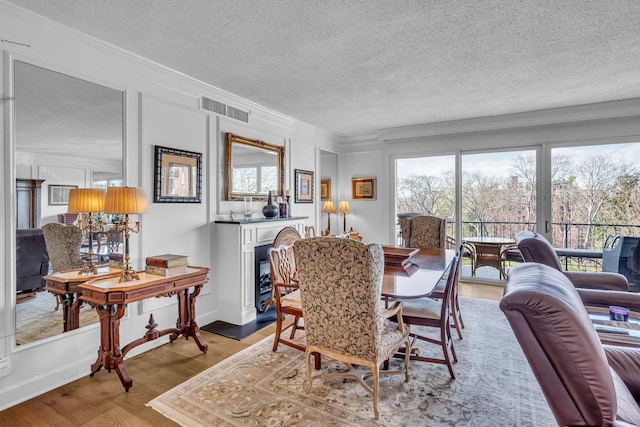 4215 Harding Pike Unit 610, Nashville, TN 37205 - dining room featuring ornamental molding, a textured ceiling, and light wood-type flooring
