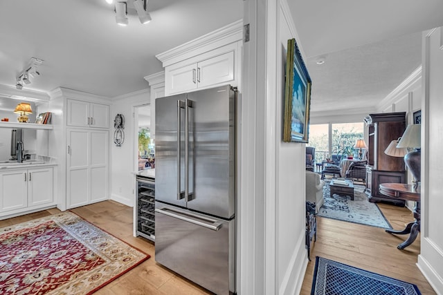 4215 Harding Pike Unit 610, Nashville, TN 37205 - kitchen featuring high end fridge, wine cooler, white cabinetry, light wood-type flooring, and ornamental molding