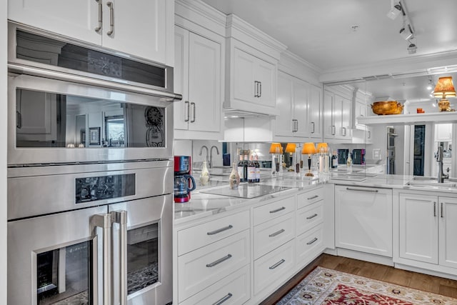 4215 Harding Pike Unit 610, Nashville, TN 37205 - kitchen featuring black electric cooktop, a sink, white cabinets, double oven, and wood finished floors