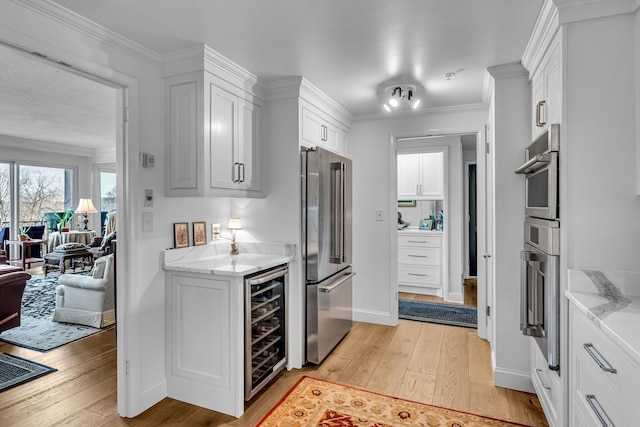 4215 Harding Pike Unit 610, Nashville, TN 37205 - kitchen featuring high end fridge, wine cooler, light wood-type flooring, white cabinetry, and ornamental molding