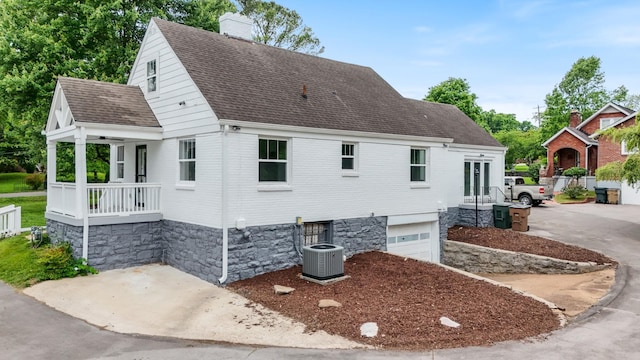 1305 Riverwood Dr, Nashville, TN 37216 - view of front of home with central AC unit, a chimney, a shingled roof, a garage, and concrete driveway