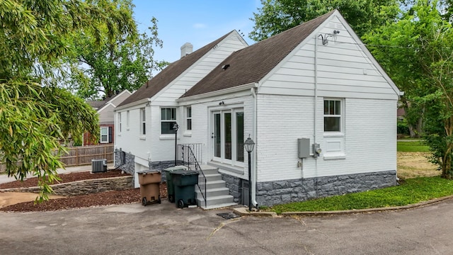 1305 Riverwood Dr, Nashville, TN 37216 - view of side of property featuring central air condition unit, a chimney, a shingled roof, and brick siding