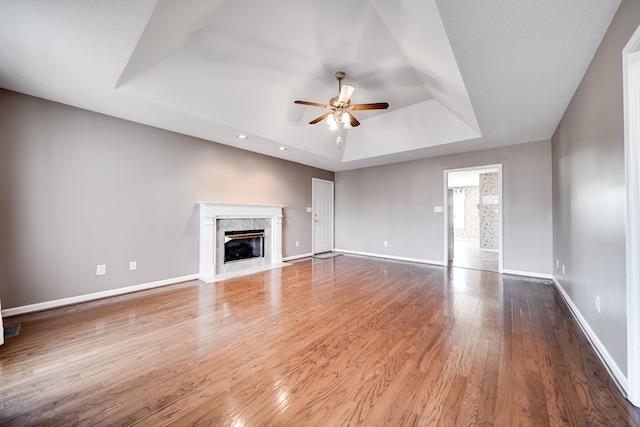 1101 Wedgewood Dr, Gallatin, TN 37066 - unfurnished living room with a tray ceiling, ceiling fan, baseboards, a fireplace, and wood finished floors