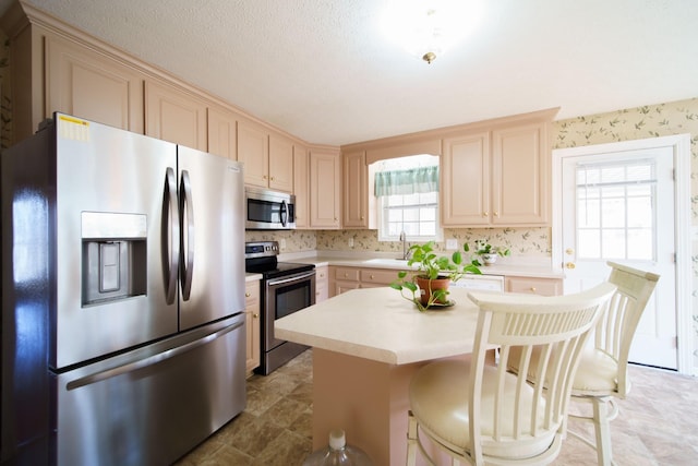 1101 Wedgewood Dr, Gallatin, TN 37066 - kitchen featuring stainless steel appliances, a sink, light countertops, a kitchen island, and a breakfast bar