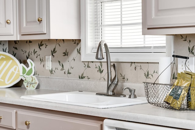 1101 Wedgewood Dr, Gallatin, TN 37066 - kitchen view of a sink, light countertops, wallpapered walls, and white cabinets