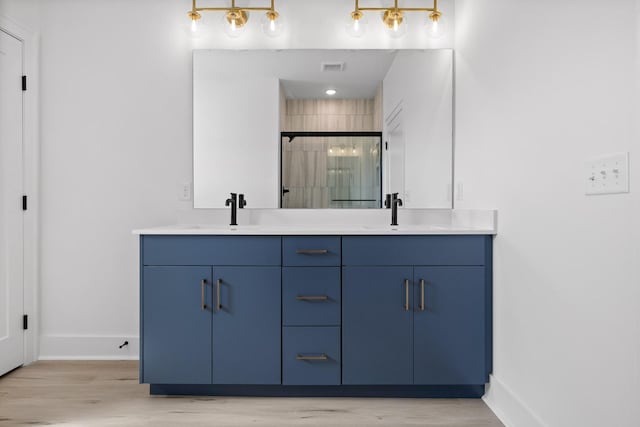 2522 E 18th St, Chattanooga, TN 37404 - bathroom with double vanity, a shower stall, wood finished floors, and baseboards